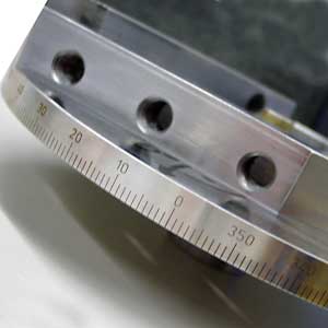 Mit einer zusätzlichen Dreh-Kipp-Vorrichtung lassen sich zylindrische Teile auf dem Umfang mit einer Genauigkeit von 0,01° skalieren.