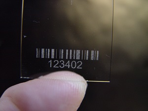 A barcode written with a laser in or on a glass plate can be read with any conventional barcode reader.